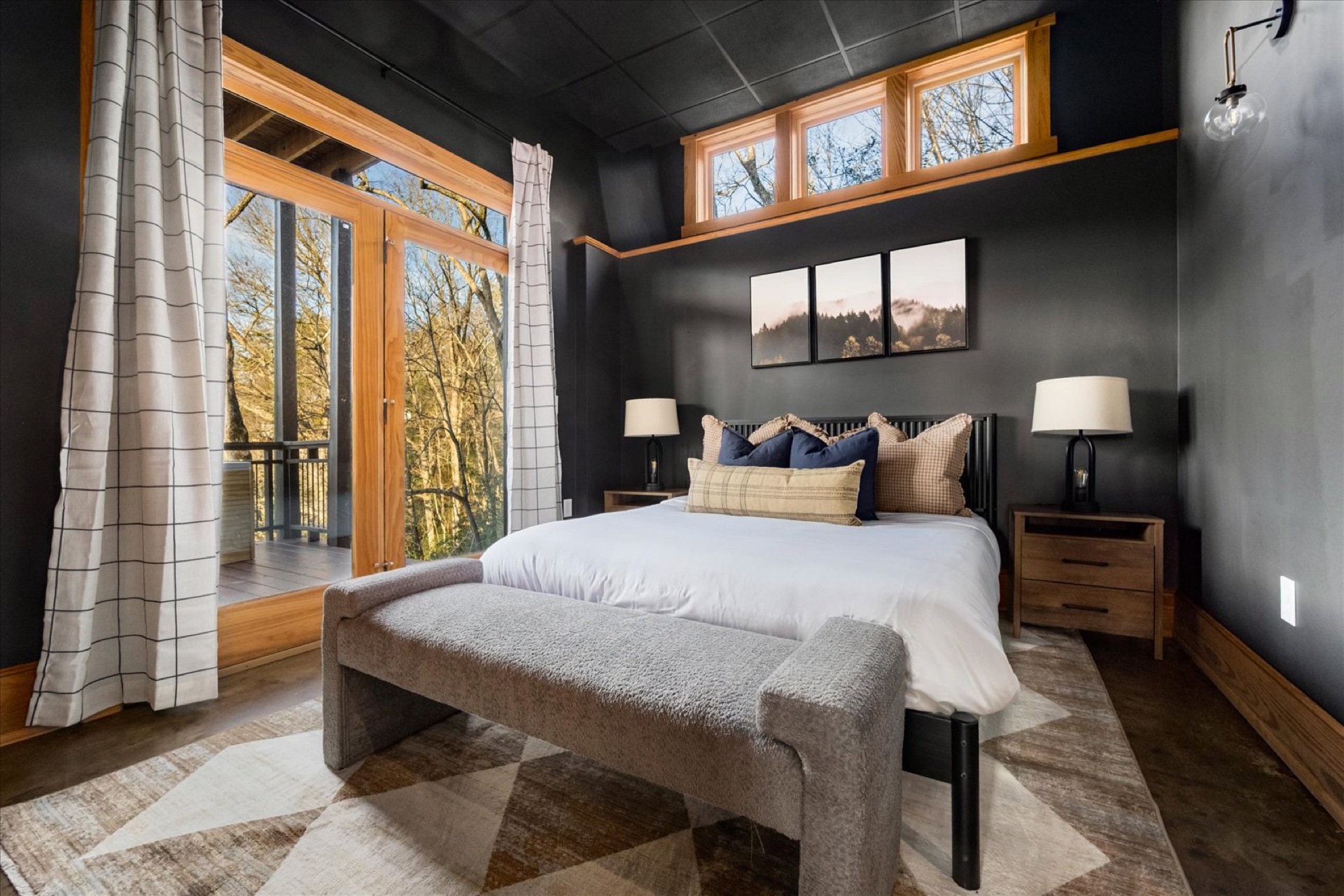 Lower Level Queen Bedroom — dark walls, large forest-view windows